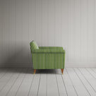 Striped green and white couch by a wall.