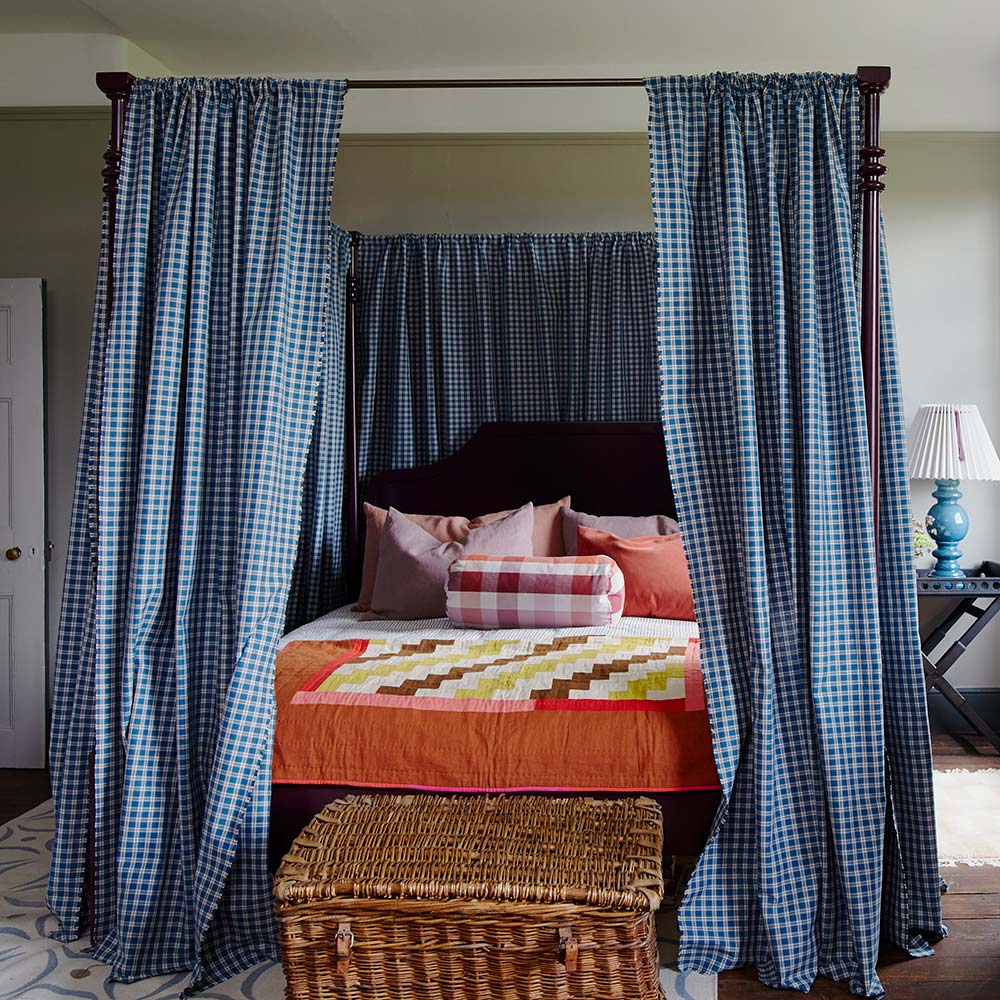 Elegant bedroom with a four-poster bed and curtains, designed by Nicola Harding & Co.