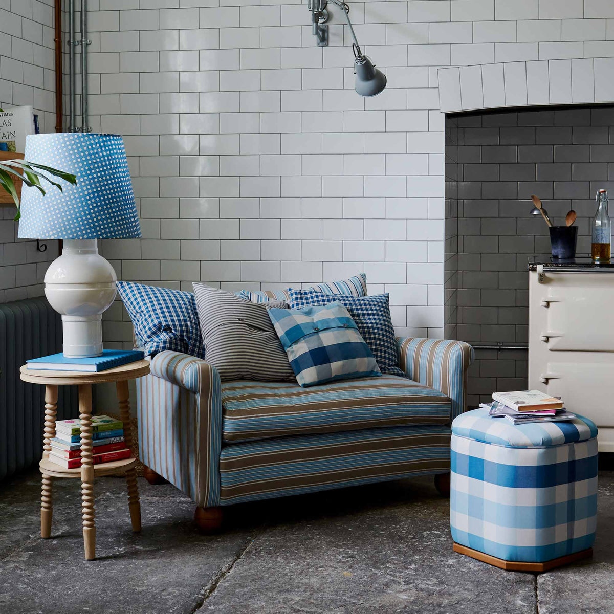 Beautifully designed living room featuring a loveseat, ottoman, side table, and lamp by Nicola Harding & Co, showcasing elegant interior styling.