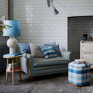 Beautifully designed living room featuring a loveseat, ottoman, side table, and lamp by Nicola Harding & Co, showcasing elegant interior styling.