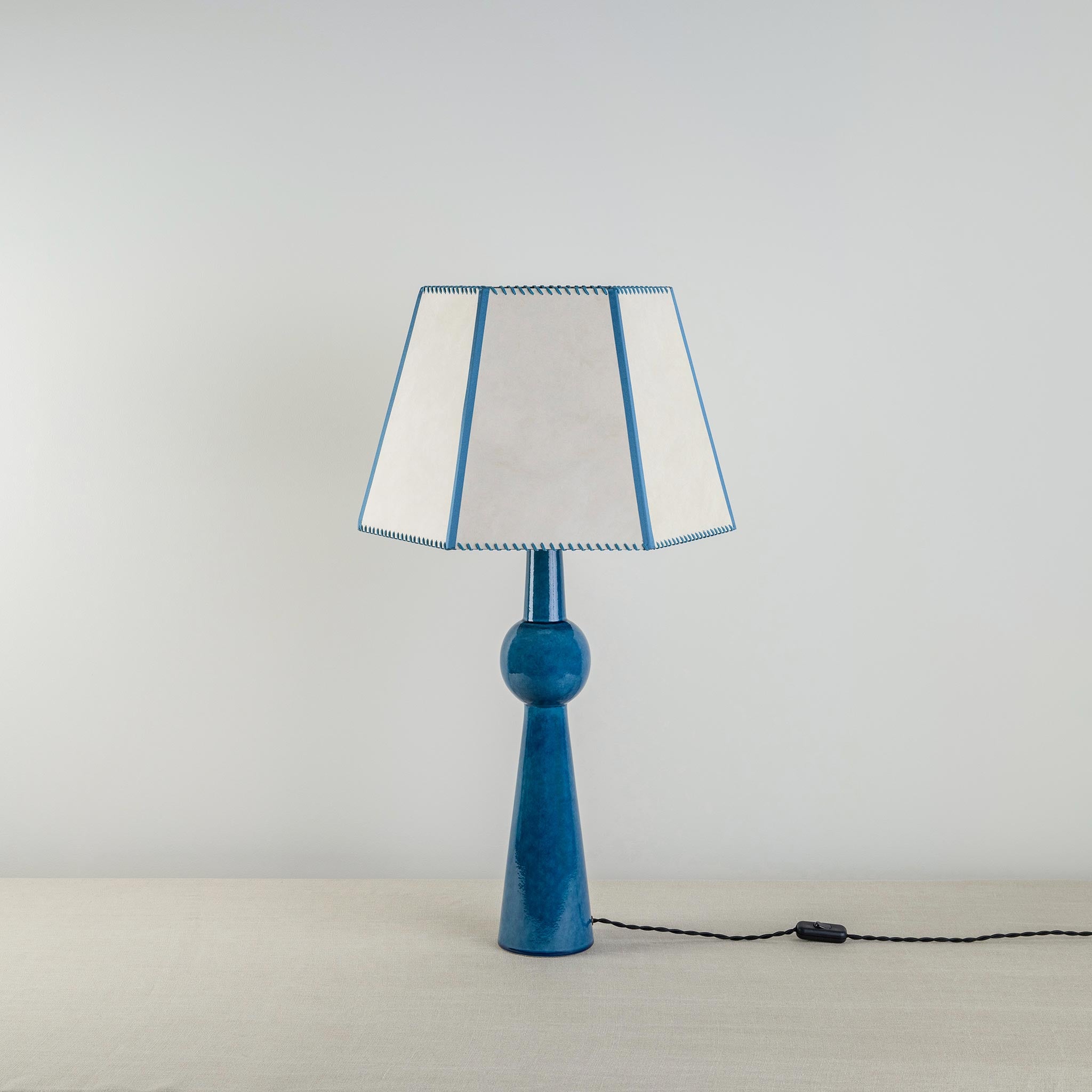  Comet Ceramic Table Lamp Base in Blue, With Townhouse Hexagonal Lamp Shade in Soft White with Peacock Blue Trim & Stitching - Nicola Harding 