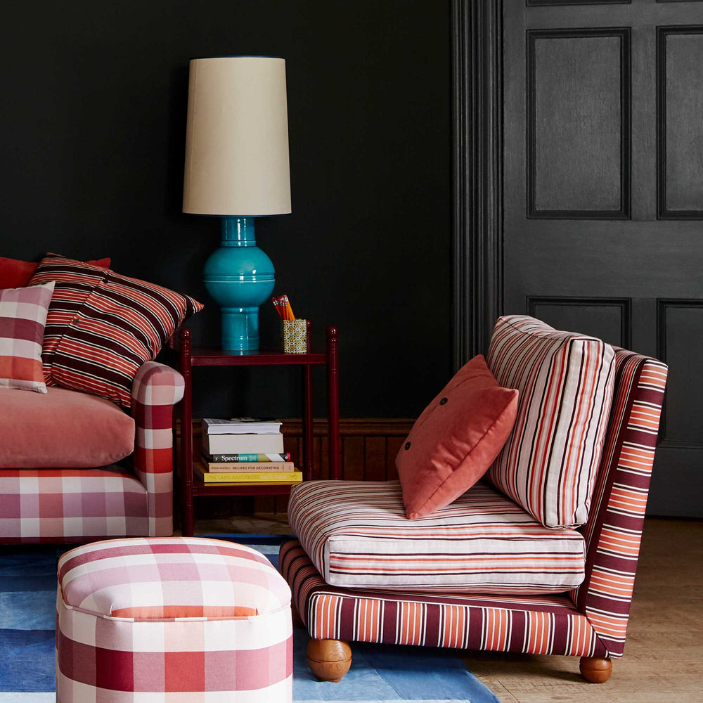 Orb Ceramic Table Lamp Base in Turquoise, With Whimsical Tall Straight Empire Lamp Shade in Soft White with Peacock Blue Trim, On a Revive Side Table, Vinho Red, and Bunch of Books on the Lower Shelve, Next To a Slipper Chair and Sofa - Nicola Harding