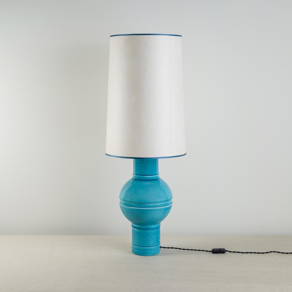 Orb Ceramic Table Lamp Base in Turquoise, With Whimsical Tall Straight Empire Lamp Shade in Soft White with Peacock Blue Trim - Nicola Harding
