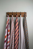 Cotton Fabric Swatches in Different Designs Hanging on Hooks – By NiX